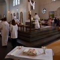 De dos, le futur prêtre, au premier plan le pain et le vin et ses ornements sacerdotaux