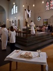 De dos, le futur prêtre, au premier plan le pain et le vin et ses ornements sacerdotaux